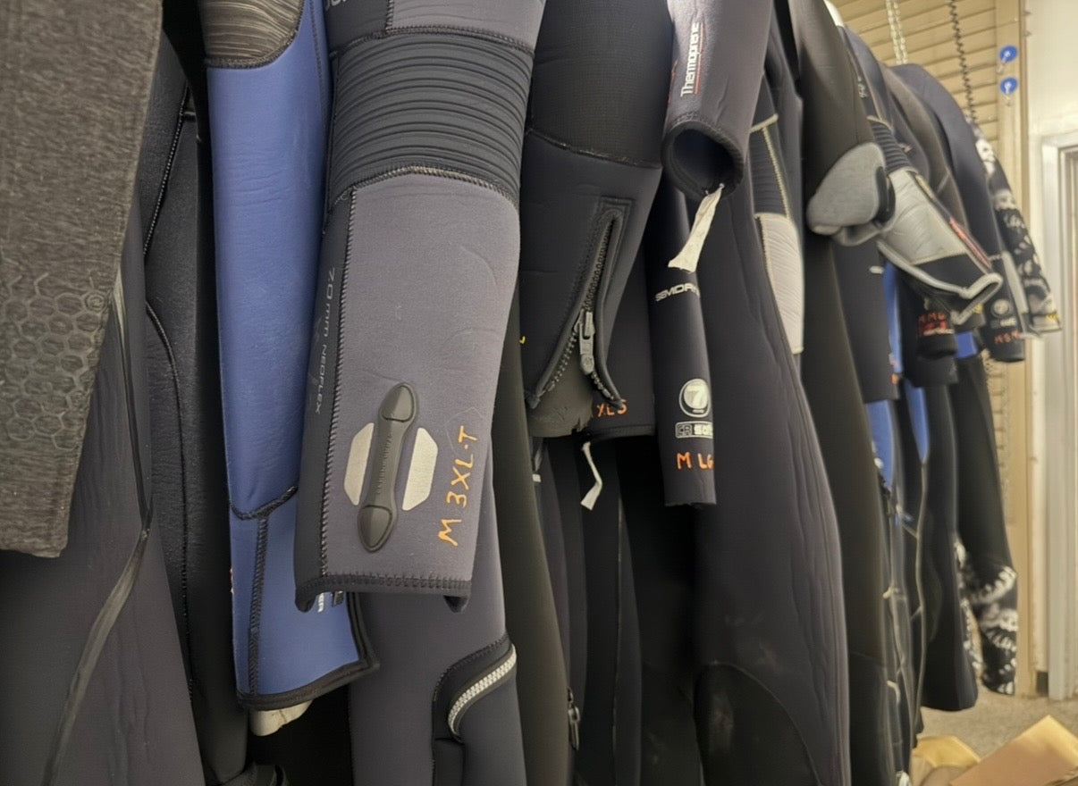 Wetsuits in a range of sizes on the Dive Arizona rental rack