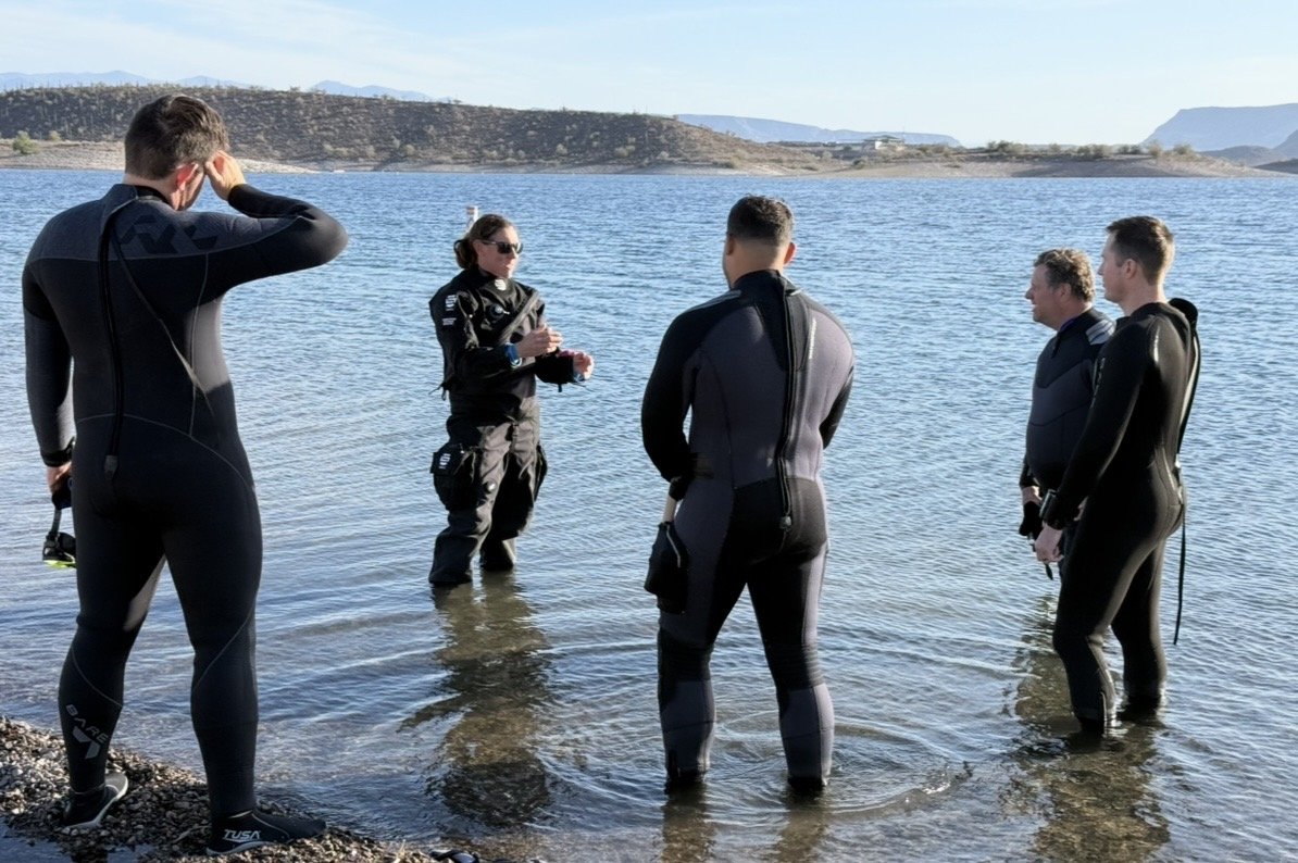 Instructor briefing students at the lake before a dive
