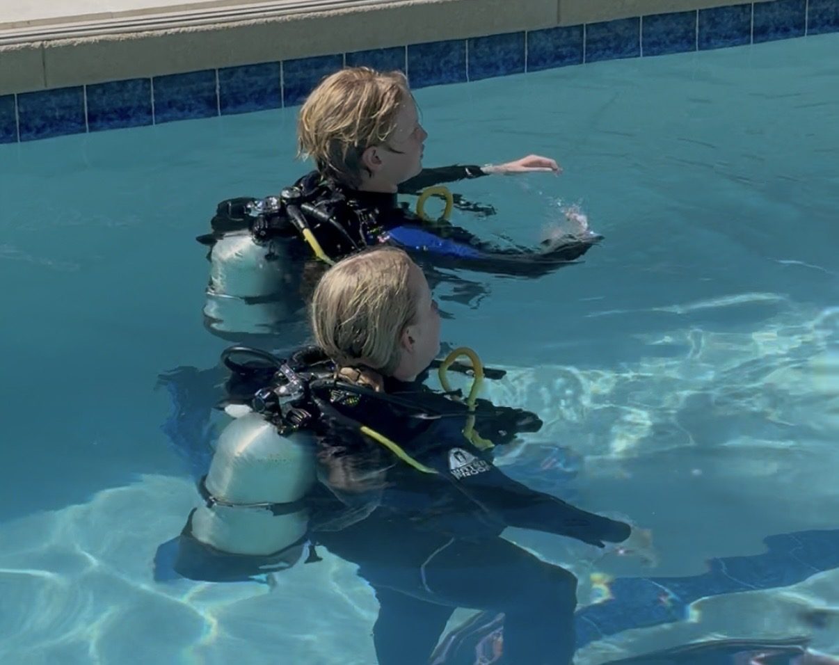 Students learning to scuba dive in a pool