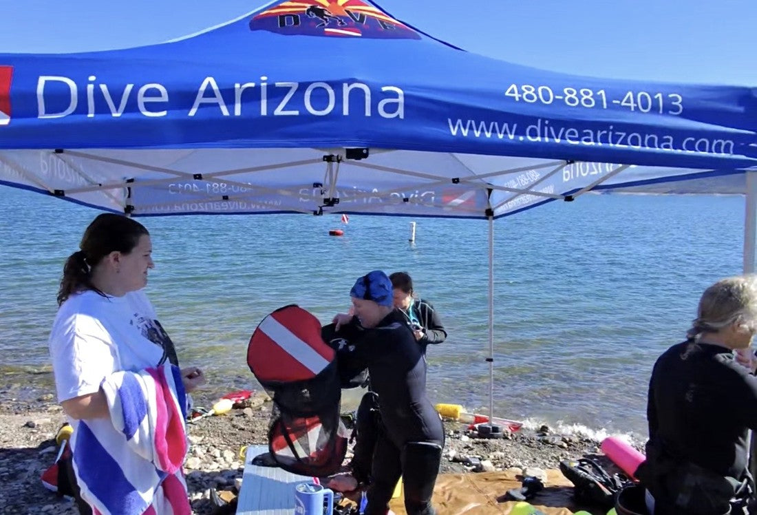 Dive Arizona instructors and students prepping gear under the Dive Arizona canopy at a lake trip